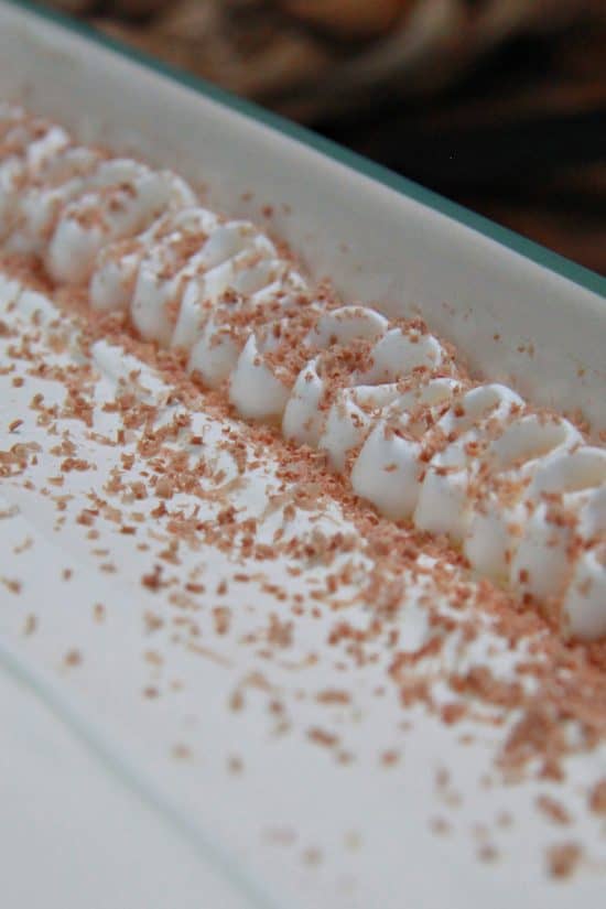 Piped on whipped cream with chocolate shavings.