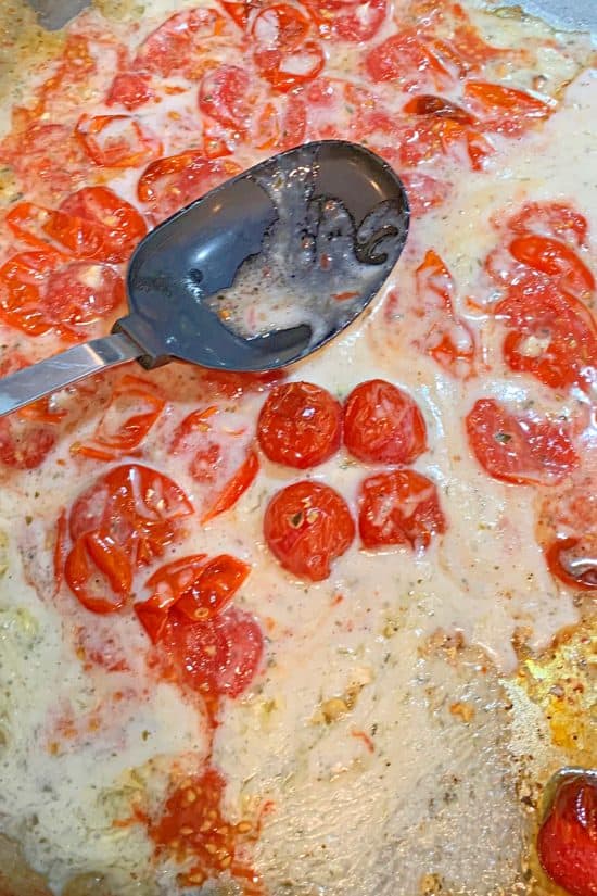 Blistered tomatoes being squashed with the Boursin cheese for a delicious sauce.