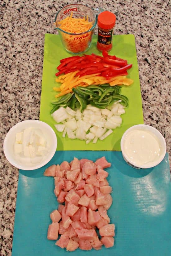 Shredded cheese, sliced bell peppers and onion, cream cheese, sour cream, taco seasoning, and cubed white meat; everything you need for a delicious meal.