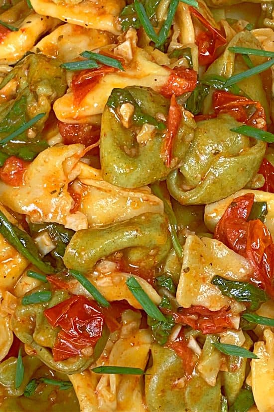 Boursin cheese and olive oil coating tender cheese-filled pasta with cherry tomatoes and baby spinach.