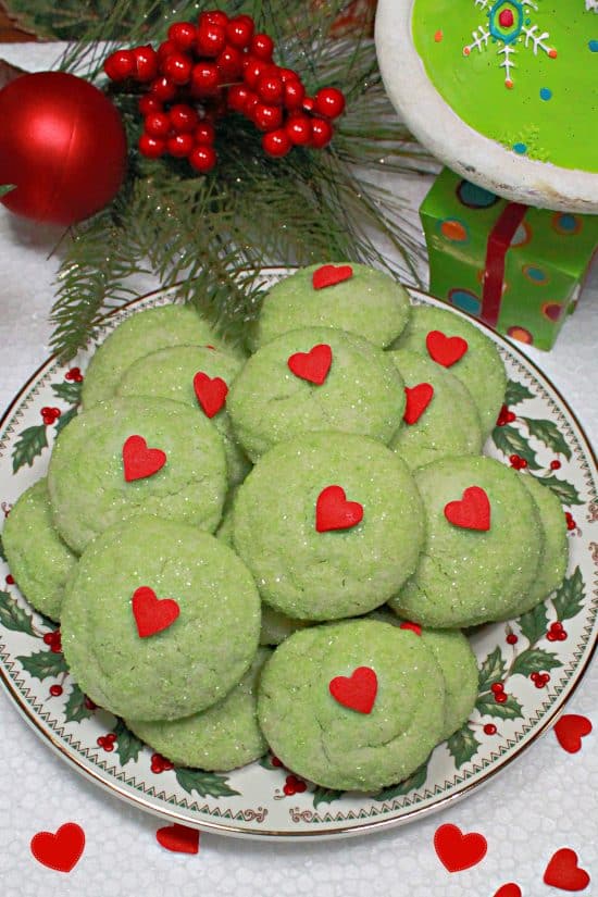 A delicious themed holiday cookie made with green sanding sugar and a red heart-shaped sprinkle.
