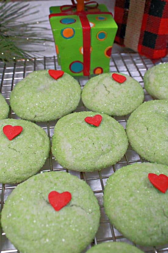 Grinch Cookies are fun to make using normal ingredients, then rolled in green sanding sugar with a heart sprinkle on top.