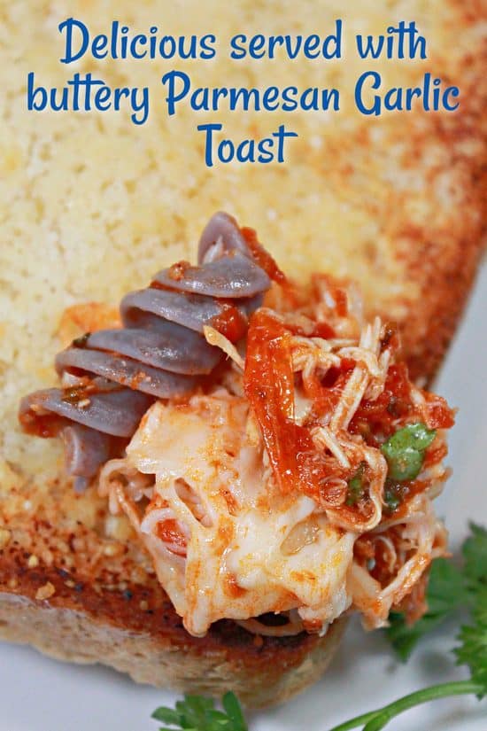 A bite of rotini with shredded chicken, marinara sauce, on garlic toast. An easy dinner that's also family-friendly.